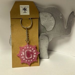 This light pink keychain is crafted in resin with the letter C in the middle